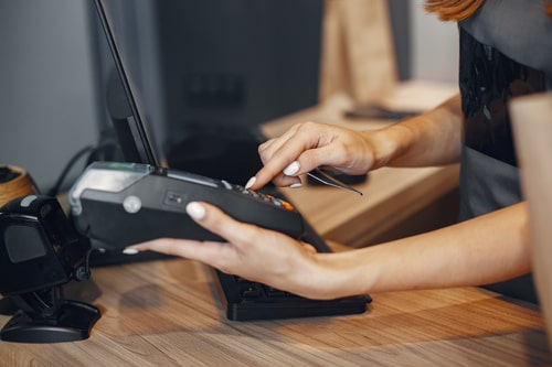 cashier-pays-by-card-through-the-terminalthe-cashier-pays-by-card-through-the-terminal
